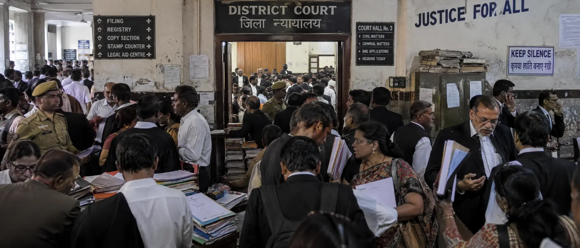 Advocates and litigants gathered in a busy district court corridor outside Court Hall No. 3